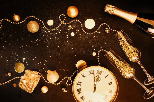 Christmas dark background. Golden Christmas items and decorations, glasses, champagne, watches. Christmas celebration concept. Flat lay top view composition